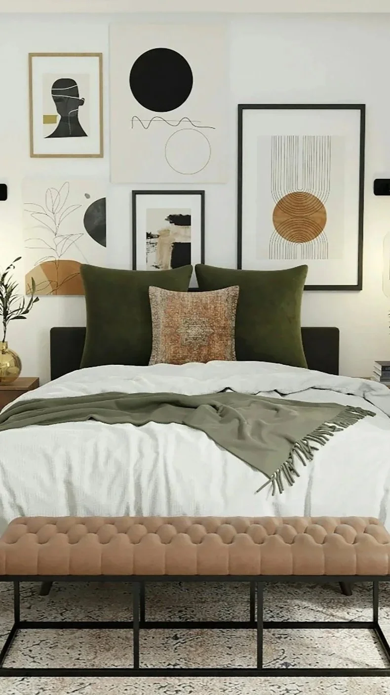 A bedroom with a bed, three large green pillows, a textured throw pillow, a beige upholstered bench, and wall art consisting of various abstract photos and prints.