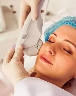 A woman at a cosmetic dermatology clinic receiving a laser skin treatment on her face.