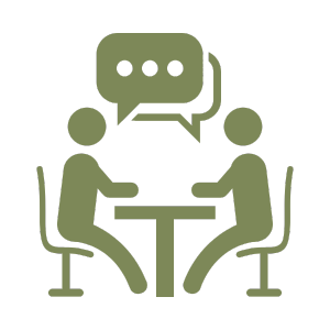 Two people sitting at a table and having a conversation, represented by speech bubbles.