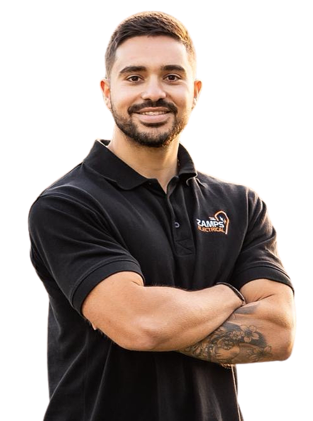 Alex from Zamps Electrical, a licensed Level 2 electrician in Sydney, standing with arms crossed in a black company polo shirt.