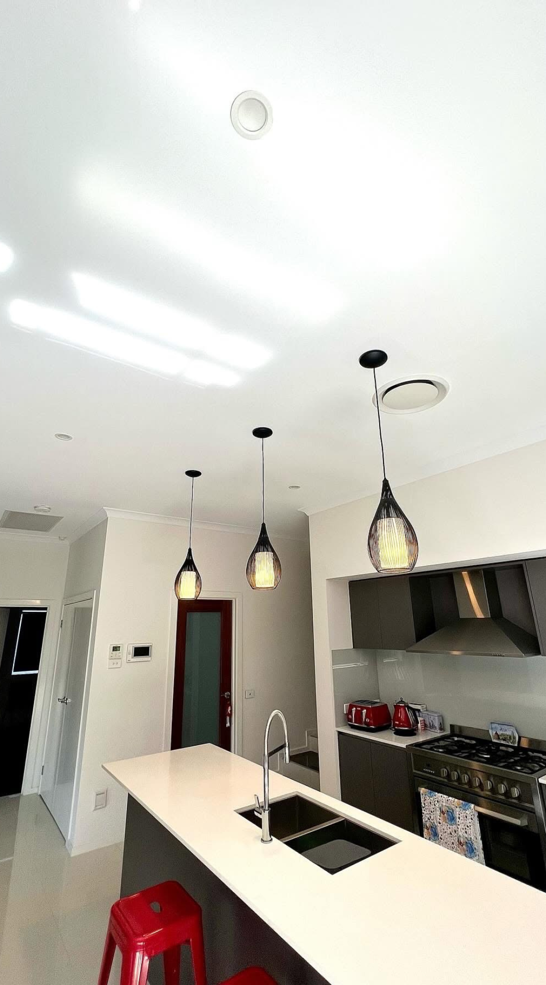 Stylish kitchen with custom lighting and modern appliances — part of a residential electrical fit-out by Zamps Electrical.