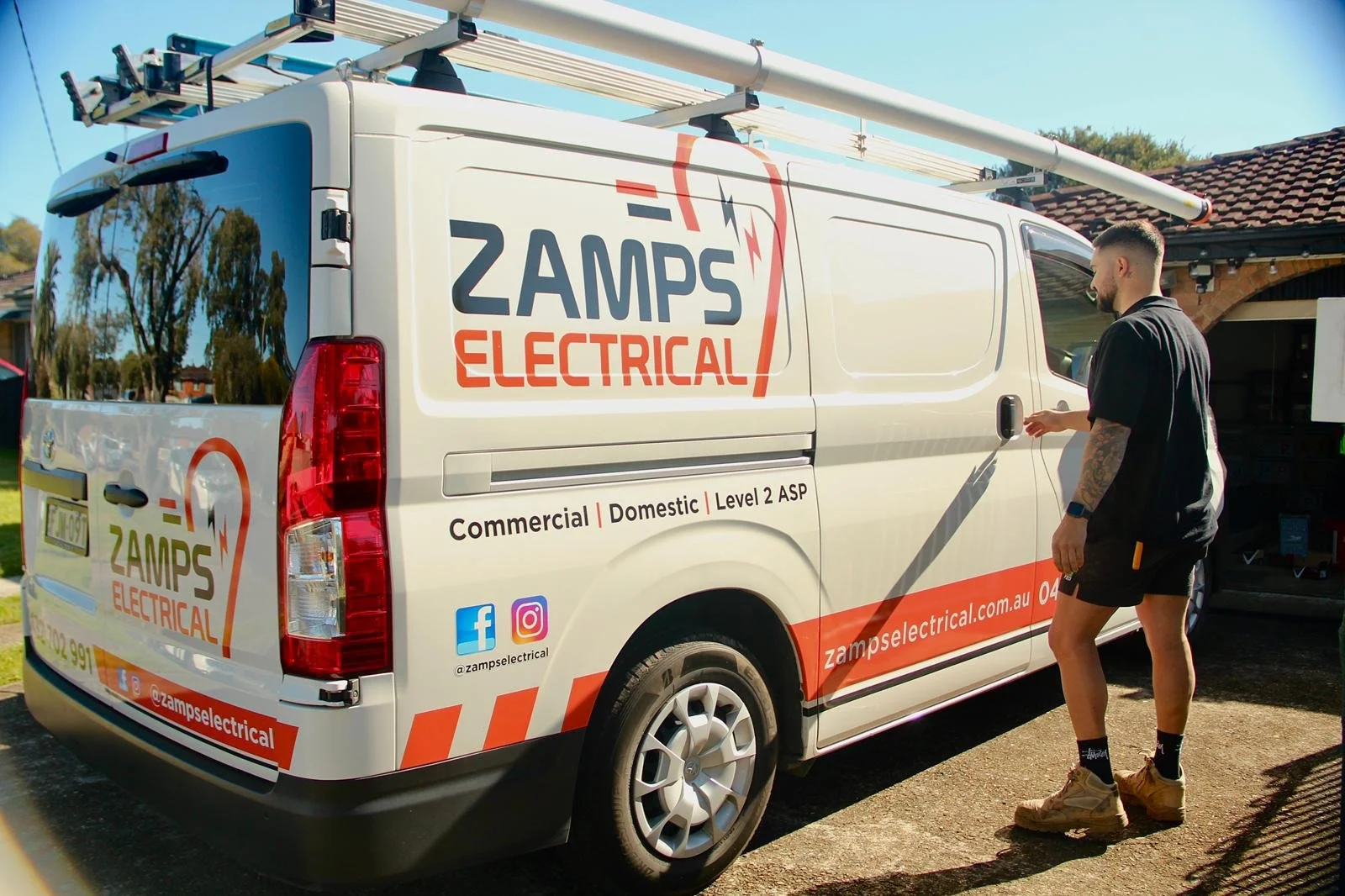 Zamps Electrical service van parked outside a Sydney home with a team member preparing for a job.