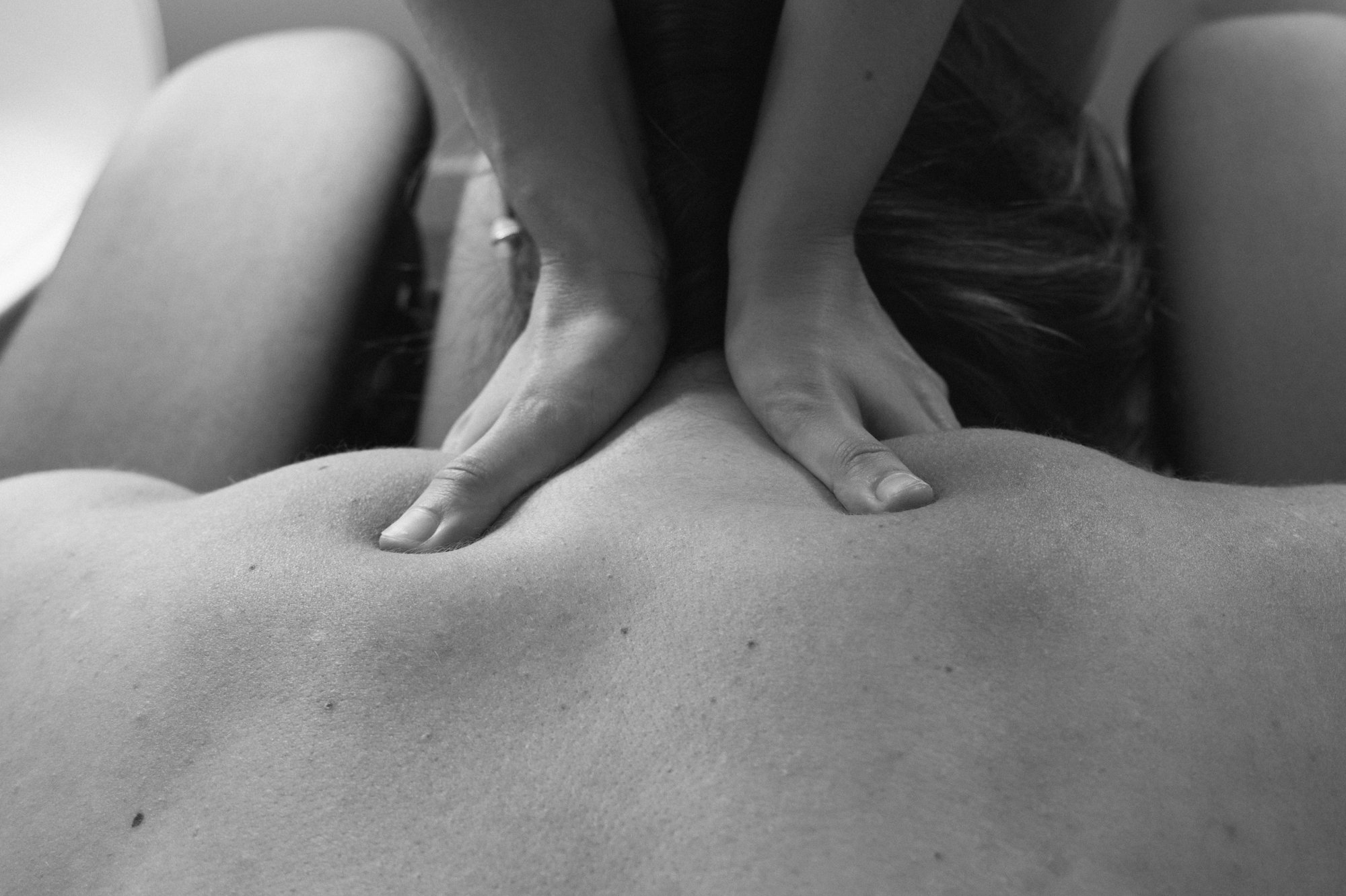 Una persona recibiendo un masaje en la espalda en un entorno relajante.