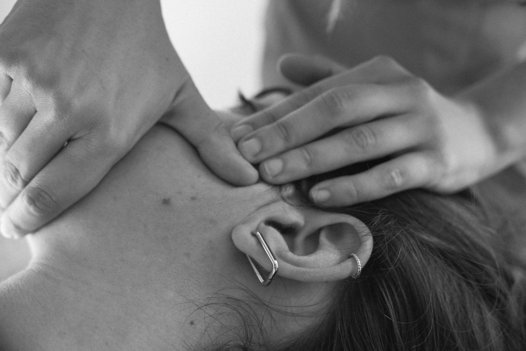 Persona recibiendo un masaje en la cabeza, con manos presionando el cuero cabelludo.