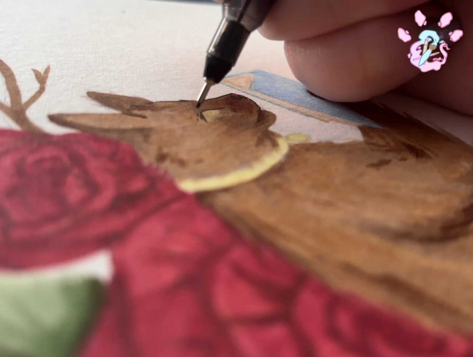 Close-up of someone using a black pen to color a detailed drawing of a deer on textured paper