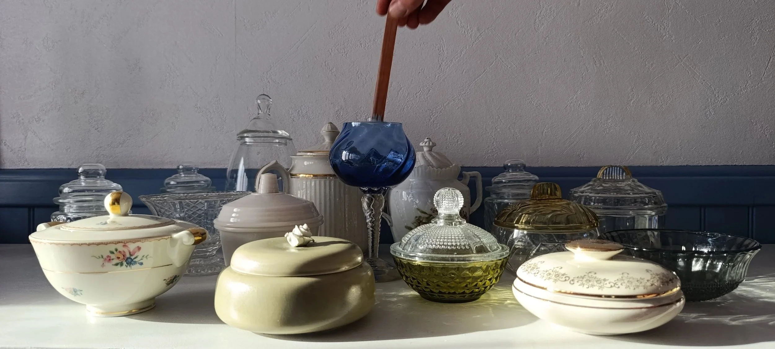 Une collection de bougie  dans des contenant en porcelaine et verre vintage