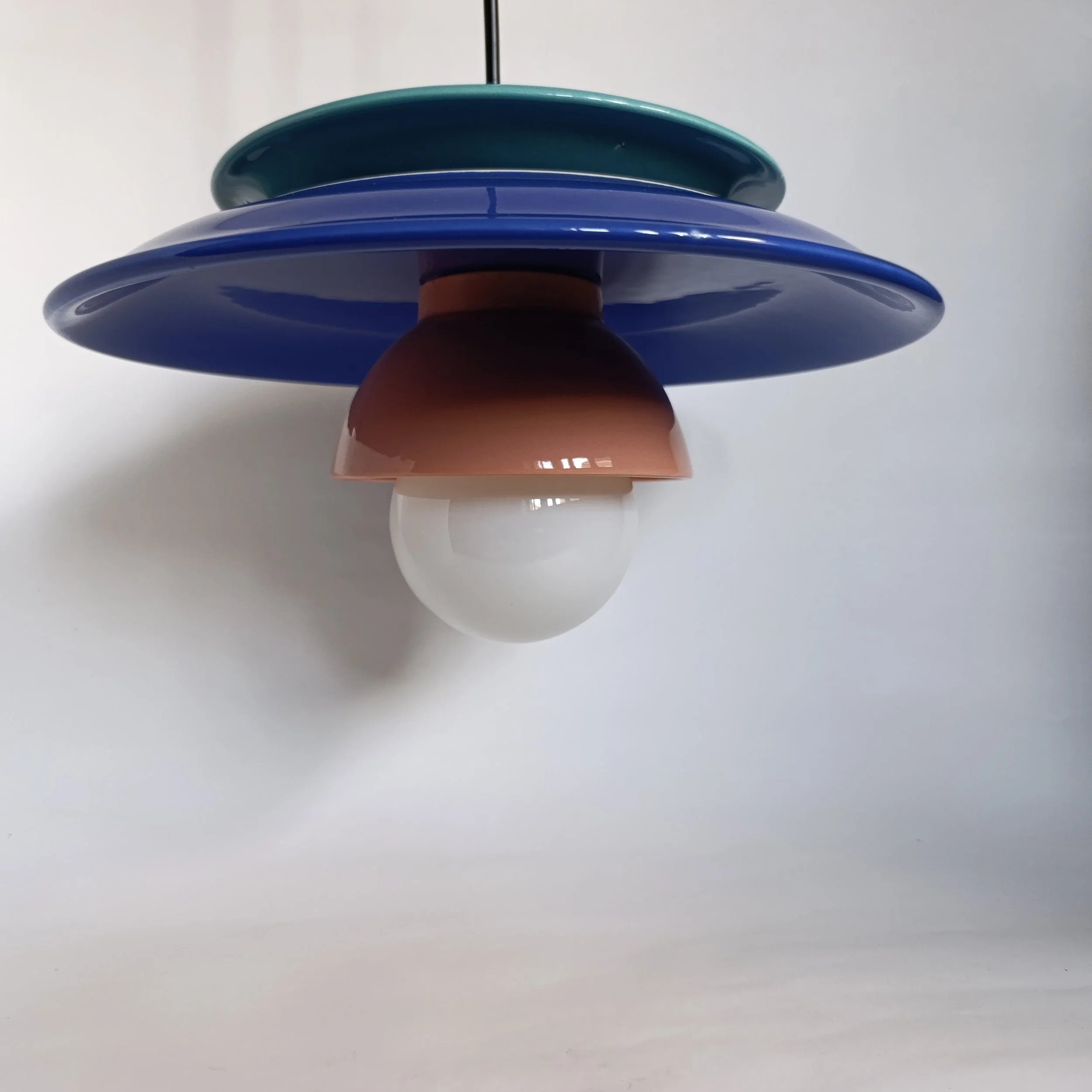 Luminaire suspendu avec plusieurs disques colorés en bleu, vert, marron et une ampoule blanche