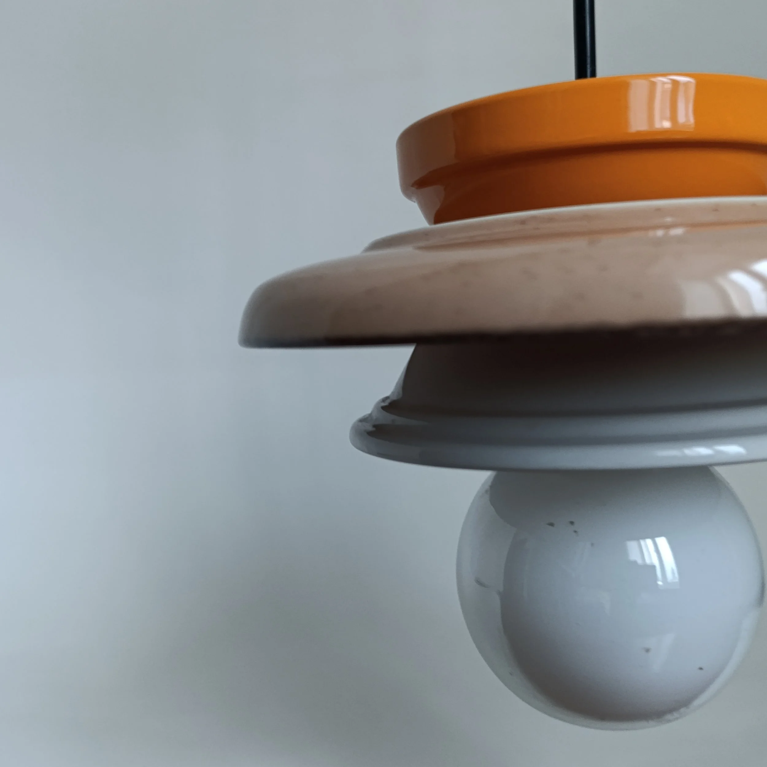 Dispositif de jeu de palets en plastique blanc avec plusieurs disques colorés empilés, notamment orange, beige et gris, sur une surface plate.