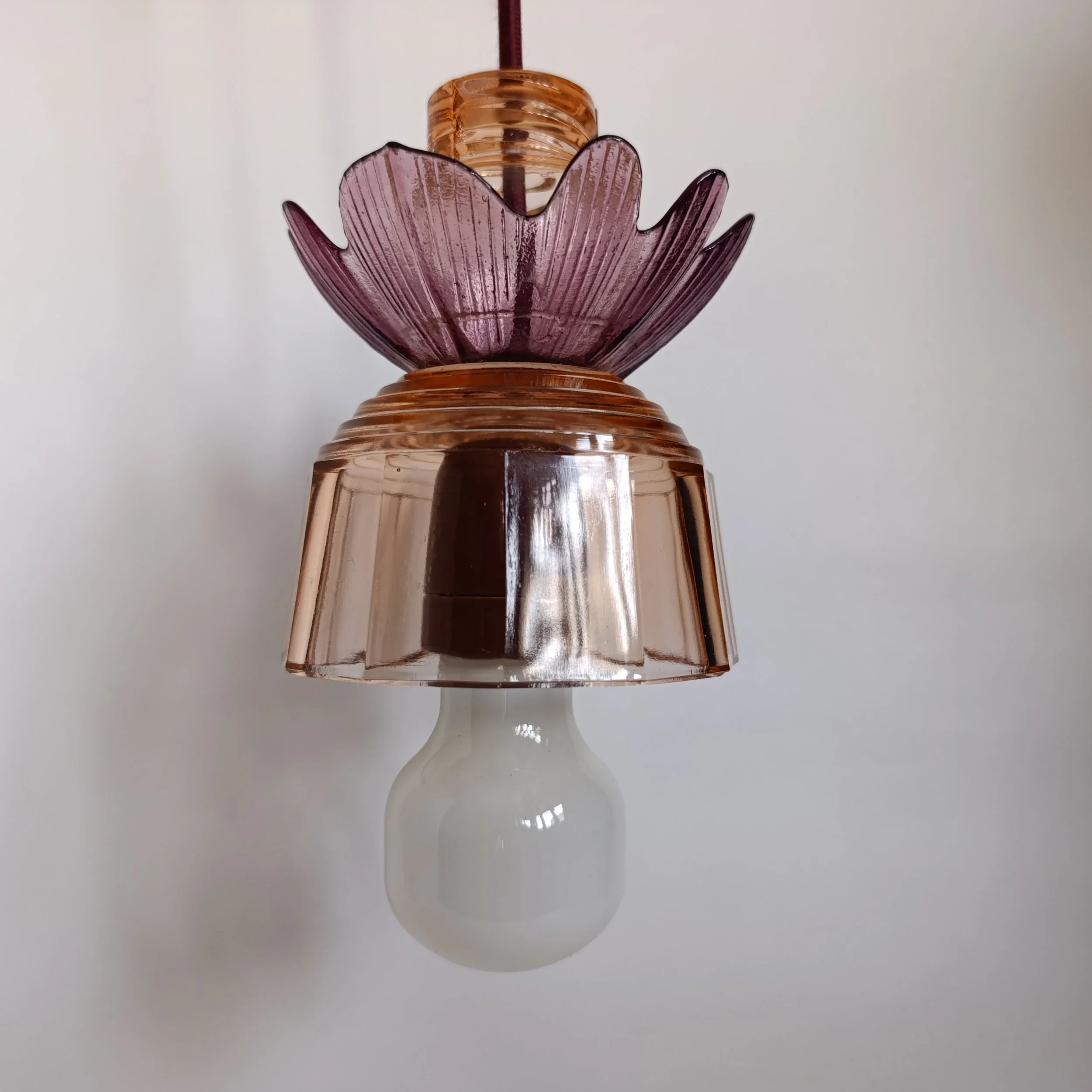 Ampoule électrique avec coquillage en décoration au sommet, vue de face.