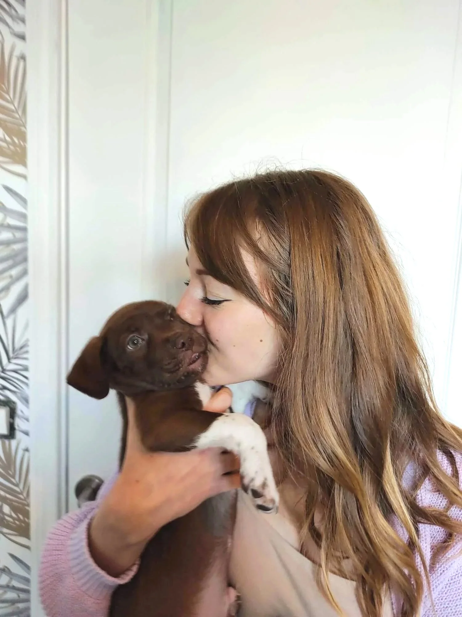 Manon Hénaux, comportementaliste canin, qui tient son chiot mignon et lui fait un bisou