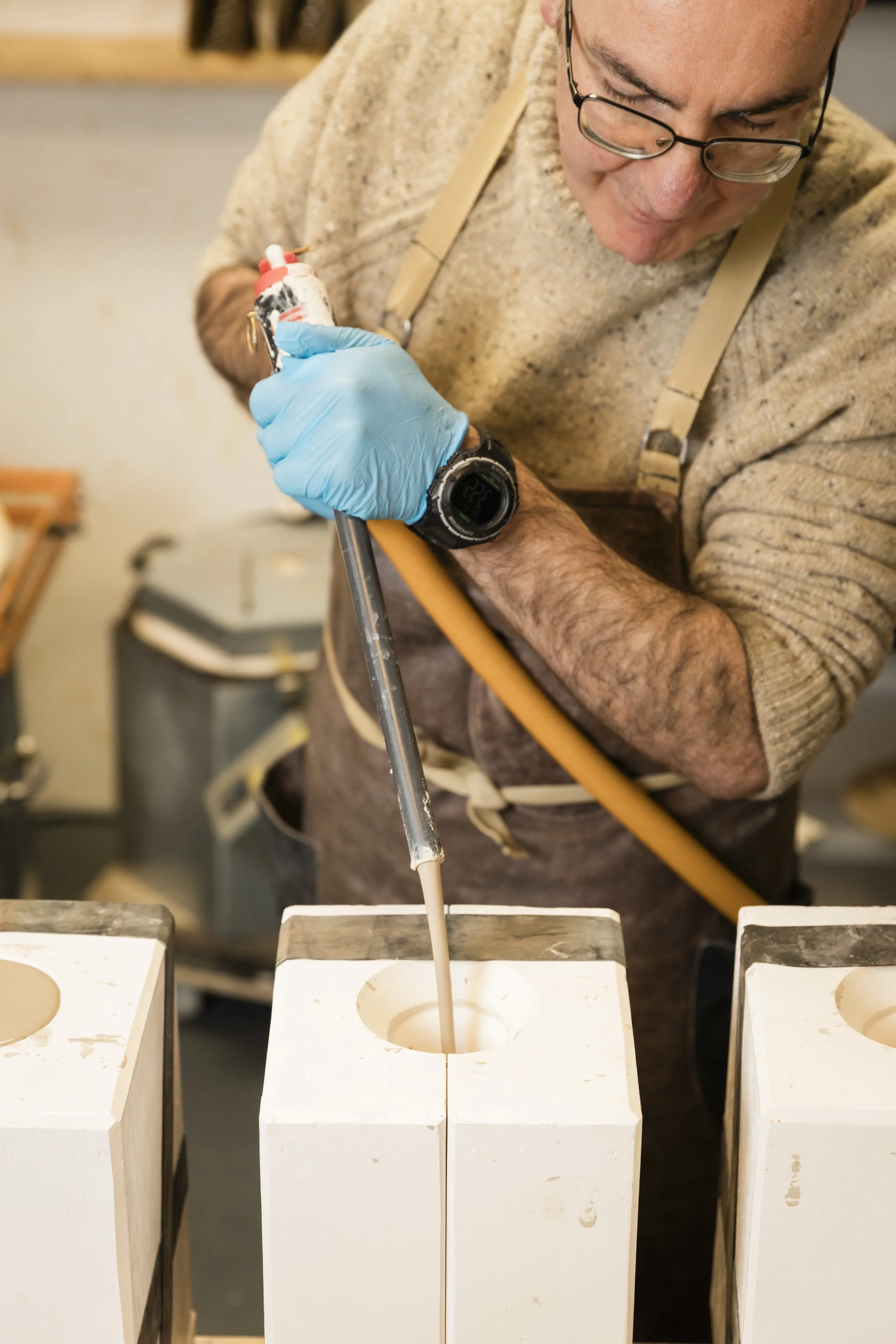 Scottish ceramics designer & maker, Arra Fletcher, pouring liquid slip into a mould in his studio.