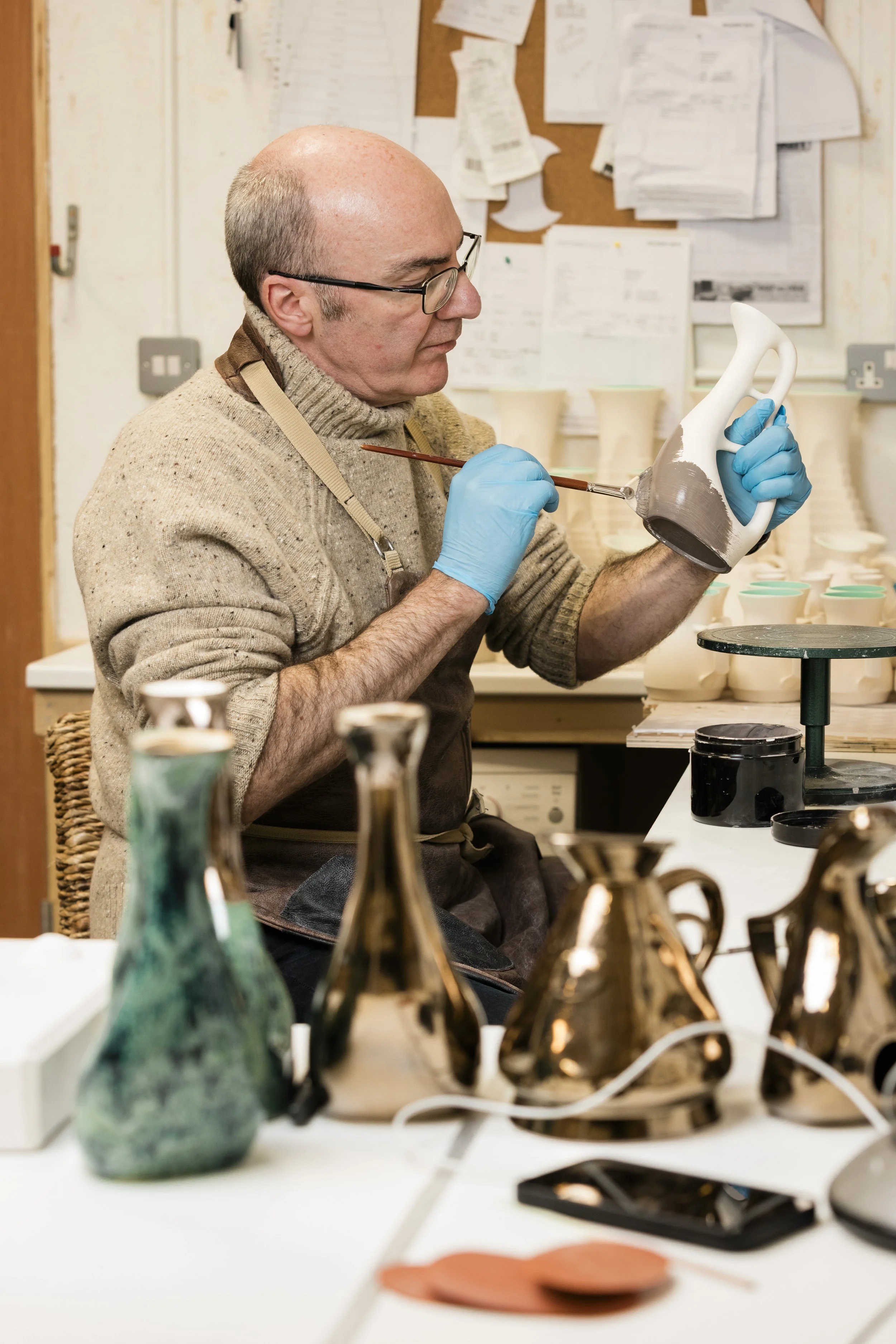 Scottish ceramics designer & maker, Arra Fletcher, glazing in his studio.