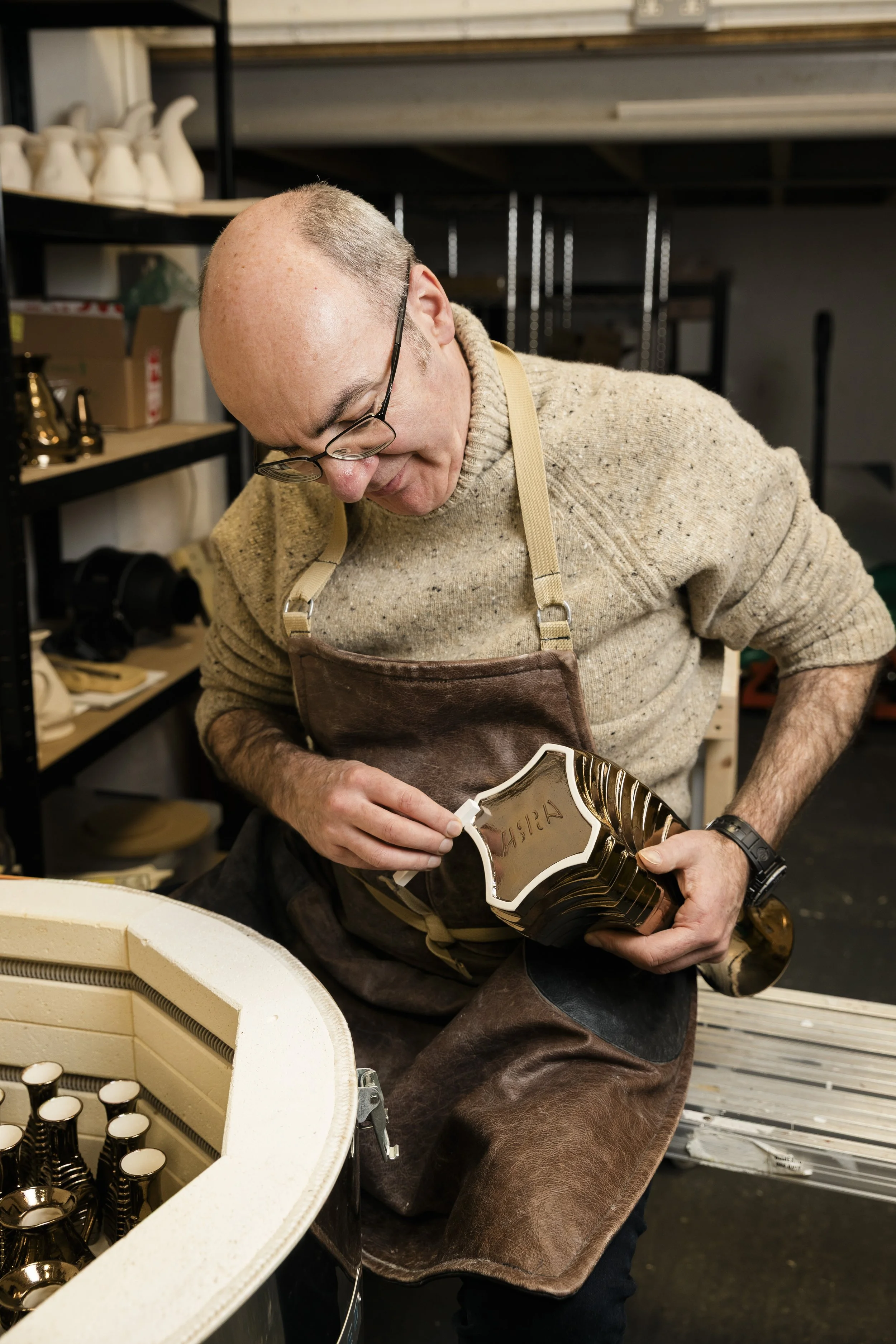 Scottish ceramics designer & maker, Arra Fletcher, inspecting and finishing a piece in his studio.