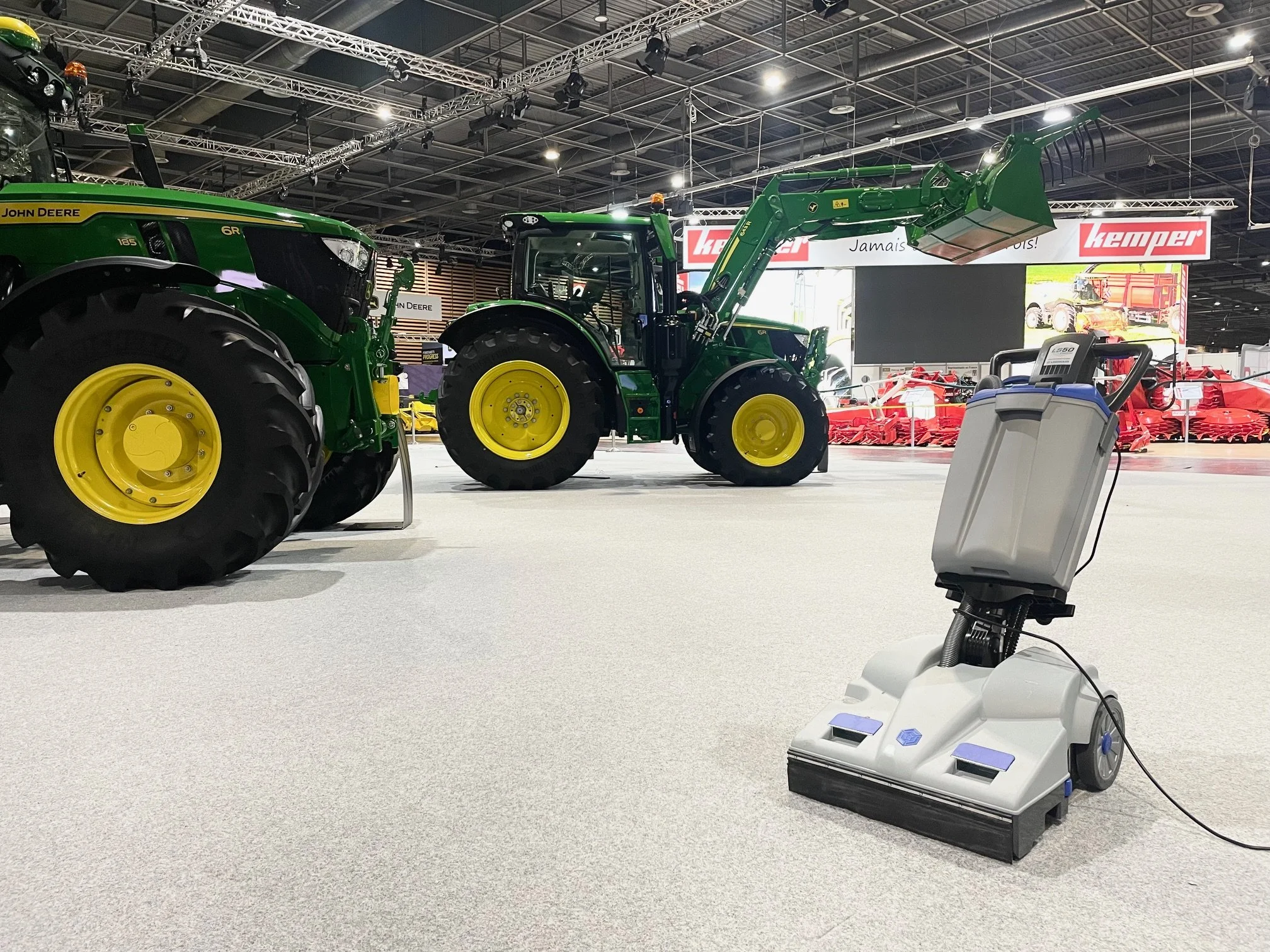 Un  aspirateur professionnel appartenant à l'entreprise AD Clean dans un salon agricole avec des tracteurs  en arrière-plan.