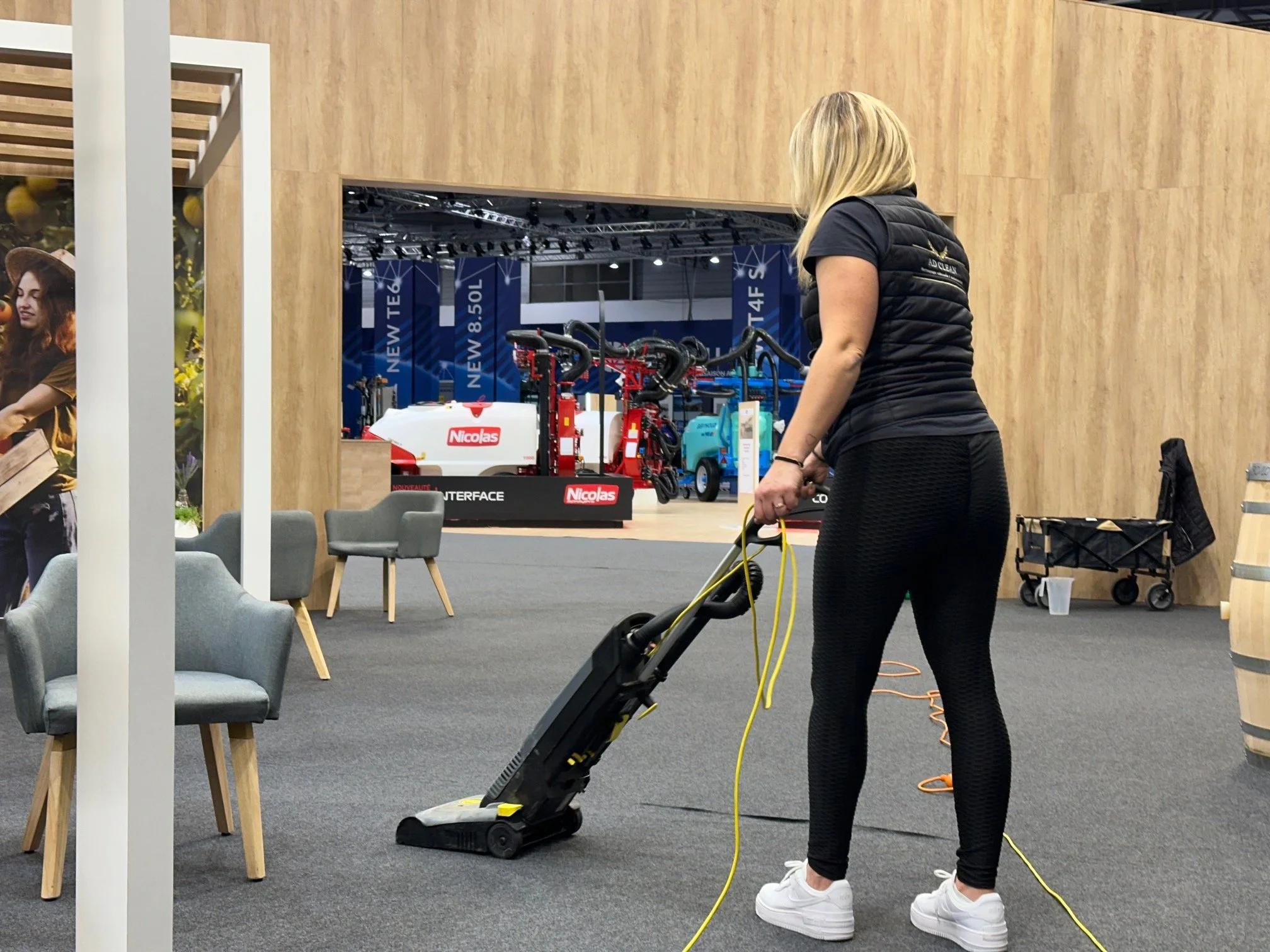 Une employée de AD Clean passe l'aspirateur dans un stand sur un événement