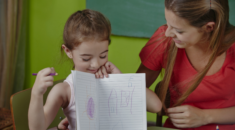 Teacher with child holding work