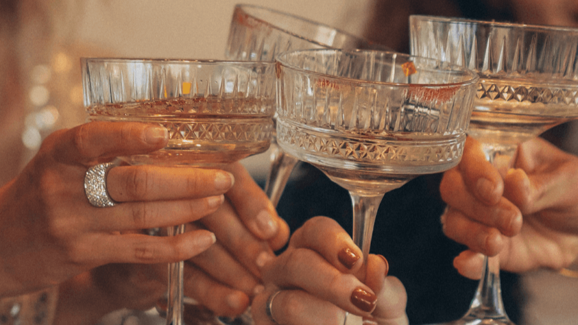 People raising glasses filled with champagne in a toast.