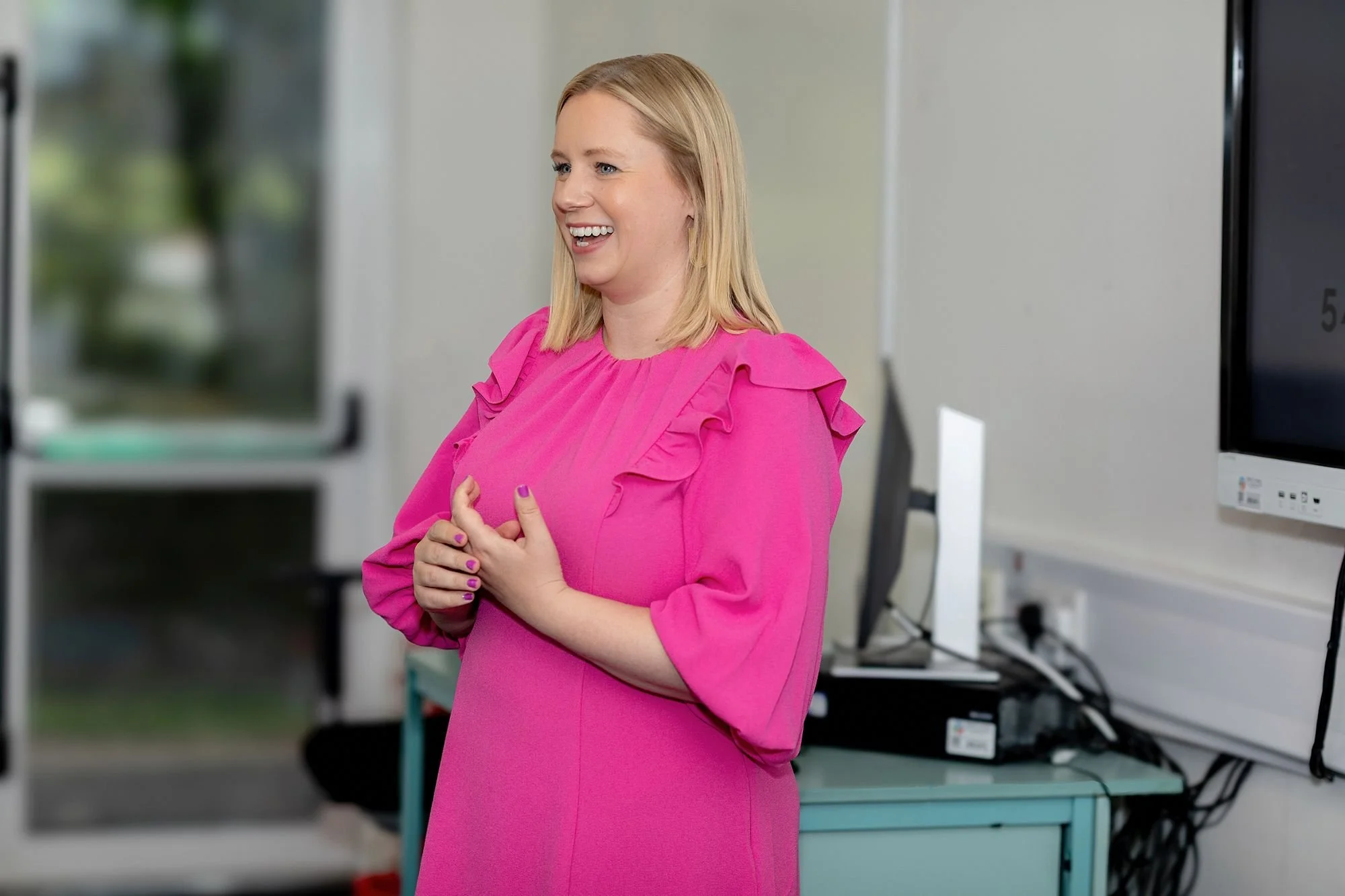 Photo of smiling lady in front of computer.