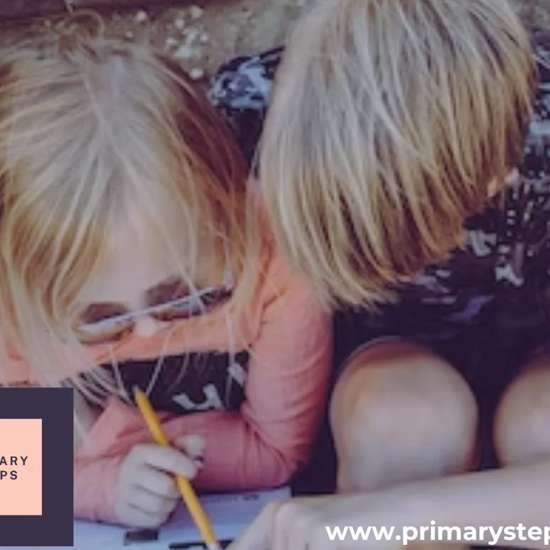 Two children with blond hair, wearing masks, engaged in drawing or writing with a yellow pencil on paper.