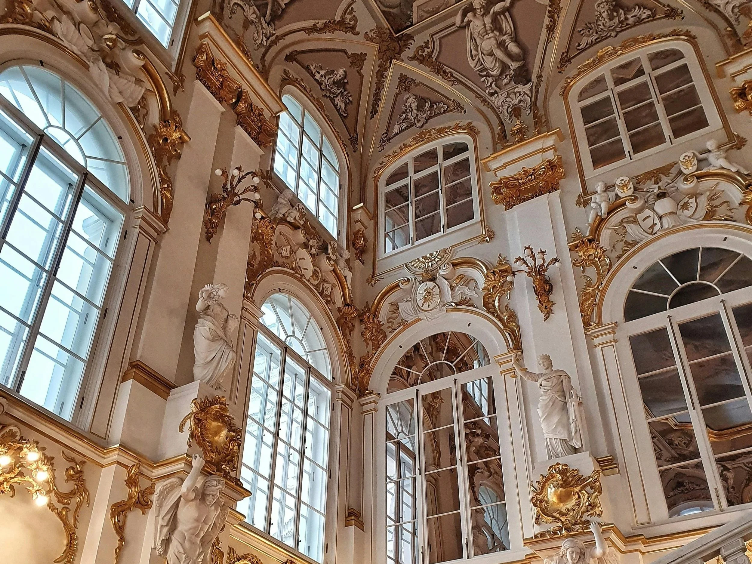A gilded, decorative and fantasy-inspired staircase with windows.