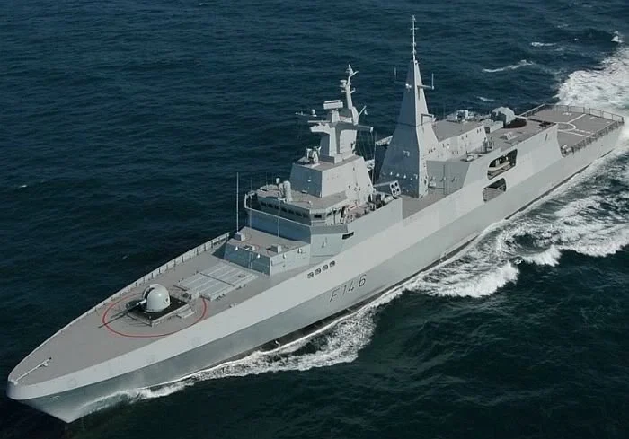 A gray military warship cruising through the ocean.