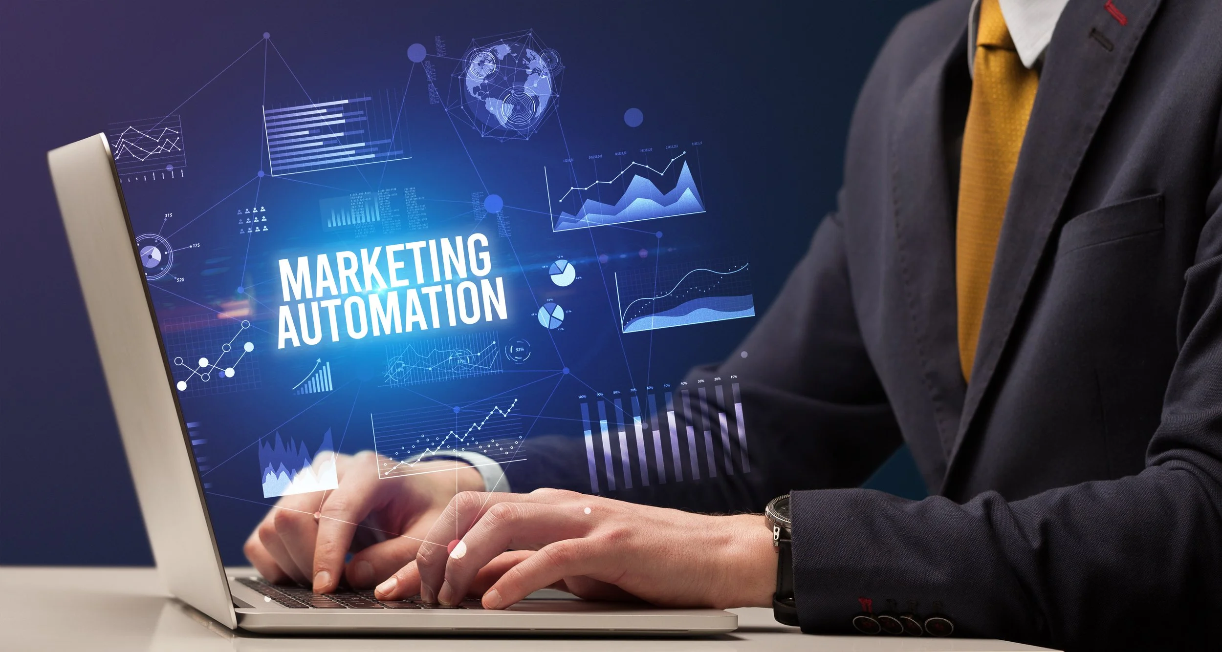 Person in a suit using a laptop with digital graphics and the words 'Marketing Automation' displayed.