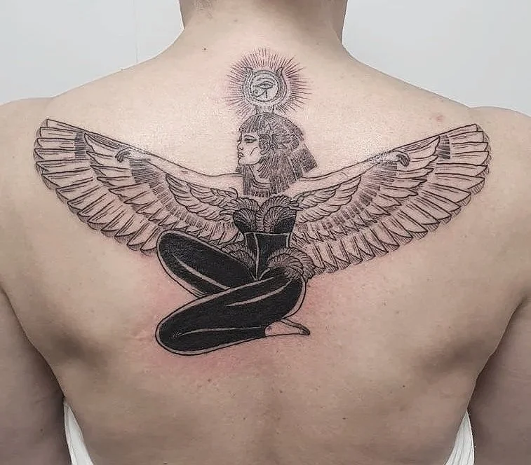 Tatuaje en el pecho que combina una figura de una mujer con alas de ave y un cuerpo de serpiente, con un halo o símbolo en la cabeza.