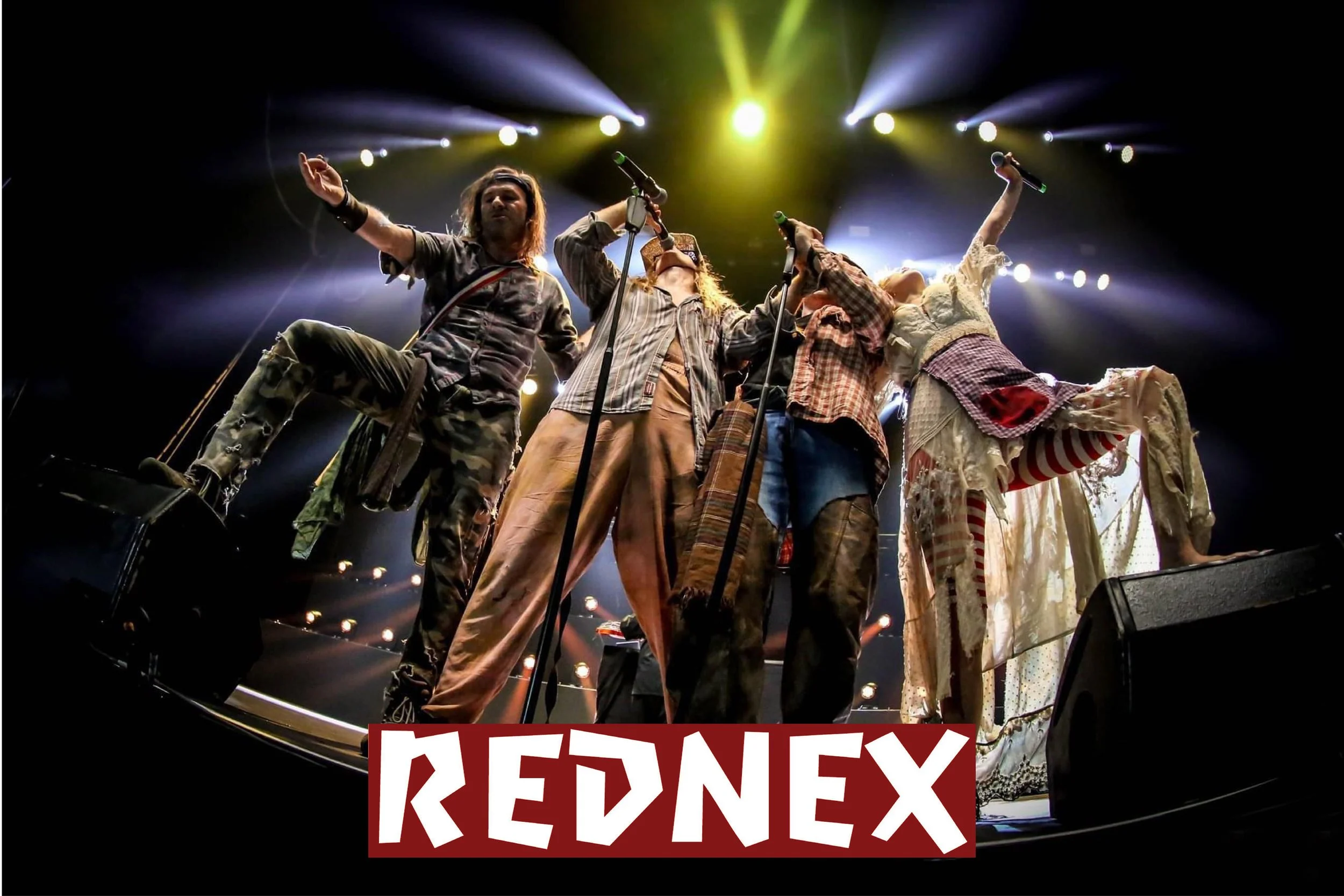 A group of performers on stage, singing into microphones with stage lights shining down, and a red and white sign reading 'REDNEX' at the bottom.
