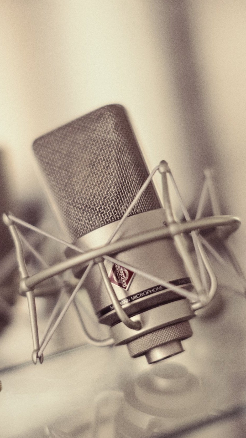 Nahaufnahme eines professionellen Mikrofon mit Popfilter auf einem Studio- oder Aufnahmetisch.