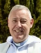 A smiling man with short hair, our chaplain Tony Carroll smiling outside Iglesia Sotogrande