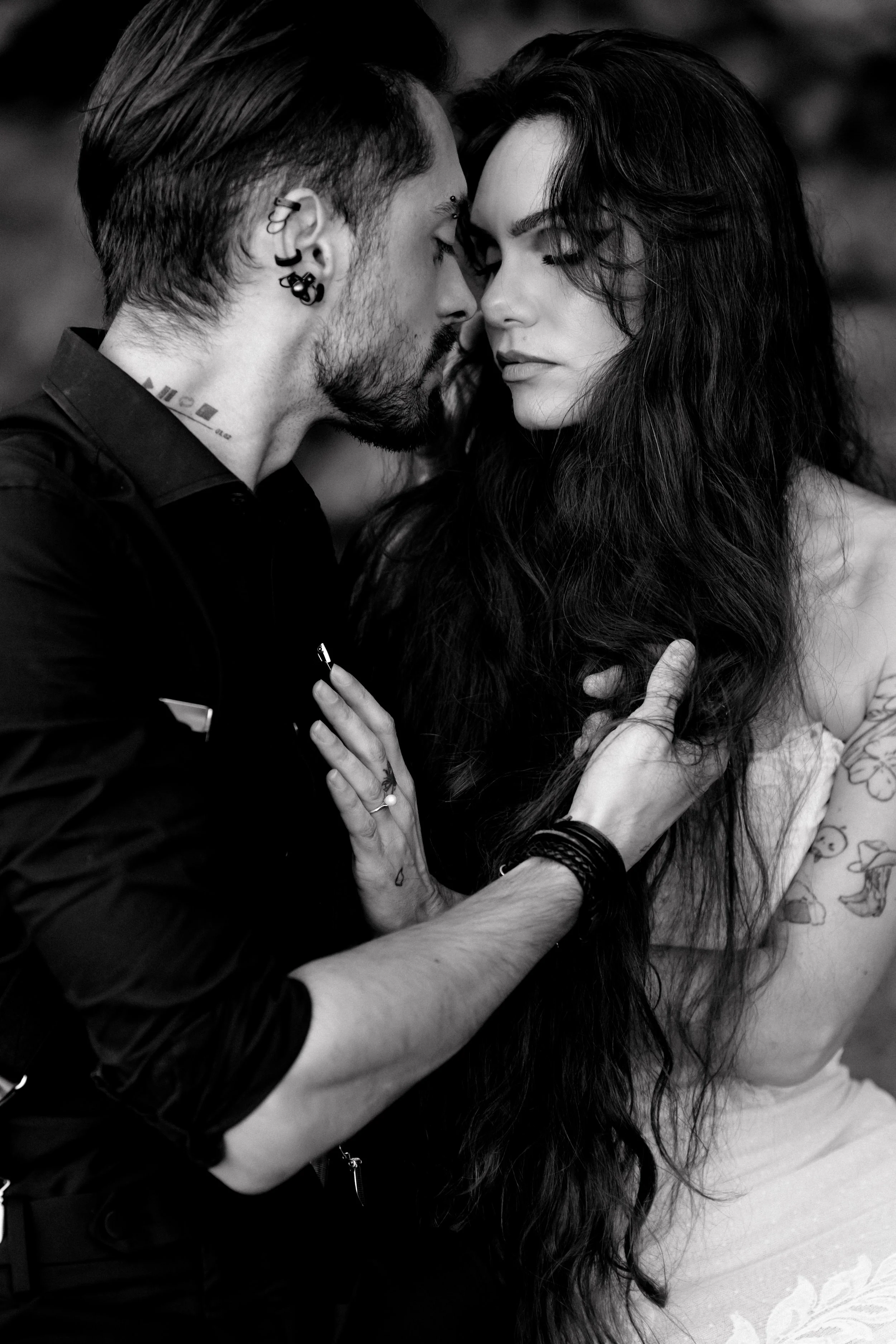 Un homme et une femme se regardent de près dans une photo en noir et blanc, exprimant une proximité intense.