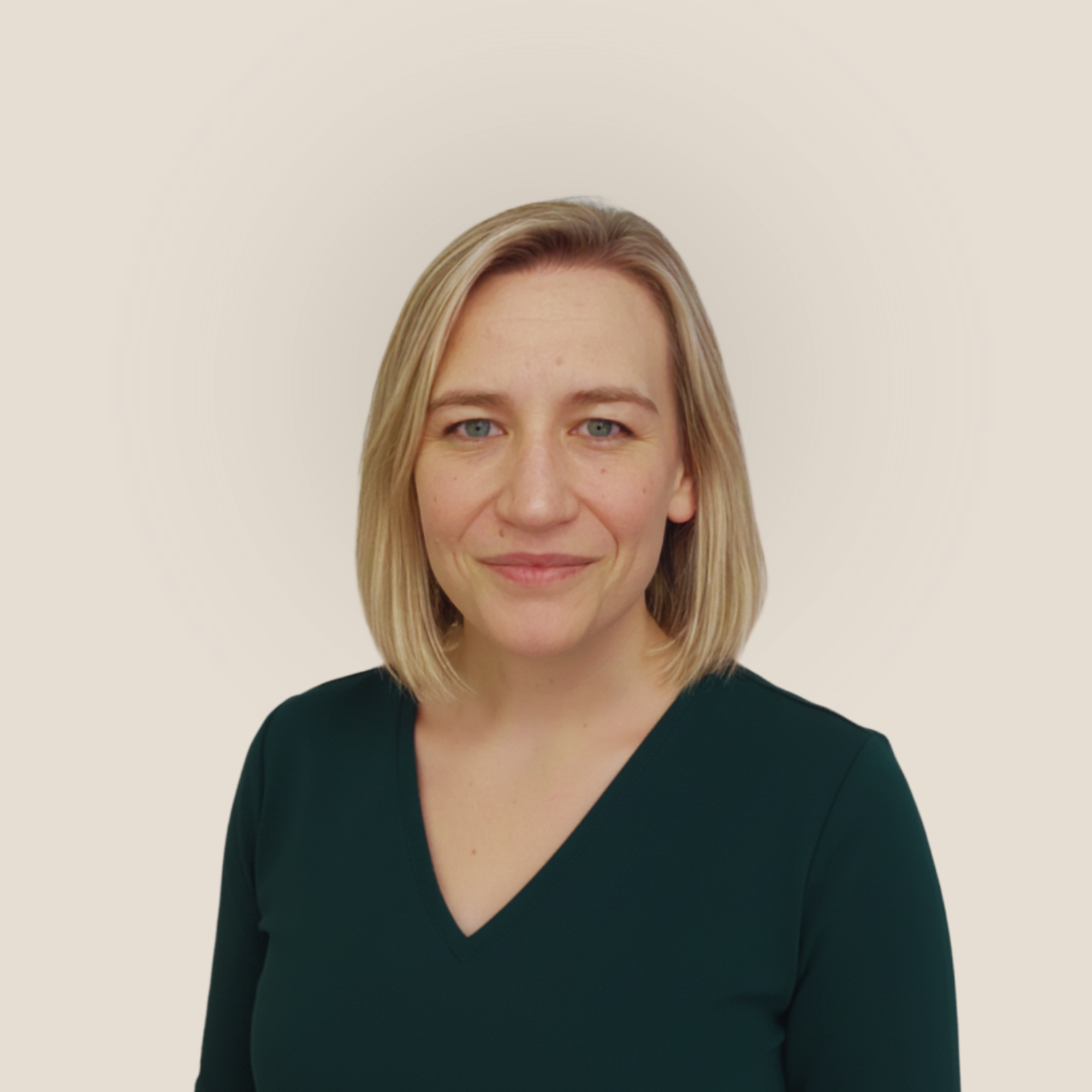 A woman with long blonde hair and glasses smiling at the camera with a plain white background. Her name is Tracey Corney 