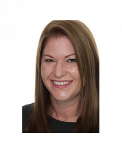 Headshot of a smiling woman with reddish-brown hair and fair skin, wearing a black top. Her name is Karen Thomas