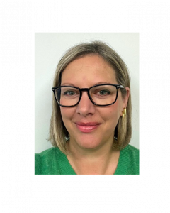 A woman with blonde hair, wearing glasses and gold earrings, smiling at the camera against a white background. Her name is Lucy Williams