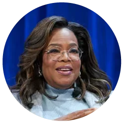 Portrait of Oprah Winfrey smiling and wearing glasses with a light blue top, featured as an endorser of Gary Zukav's book The Seat of the Soul.