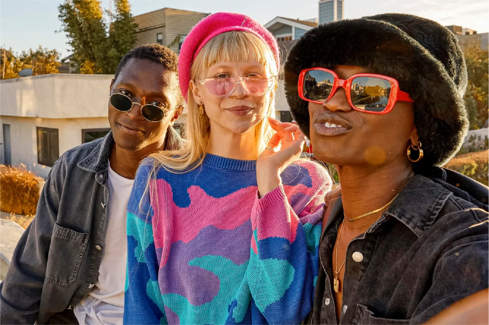 Three stylish Gen Z friends with colorful sunglasses and vibrant outfits posing together outdoors, representing Universal Human Foundation's support for building resilience, authenticity, and confidence in a hyper-connected world.