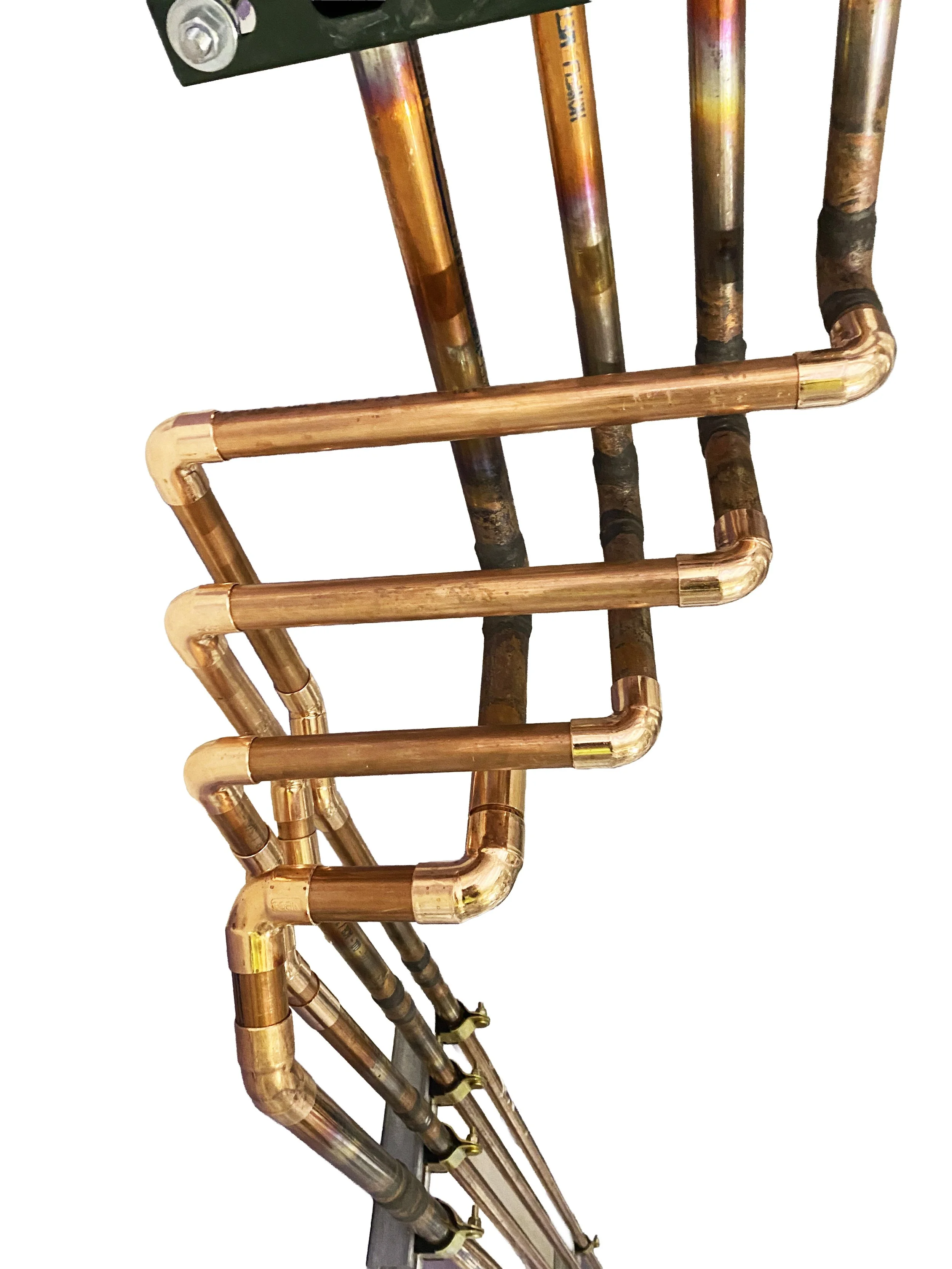 Close-up of copper pipes, some with blackened areas, connected with copper fittings.