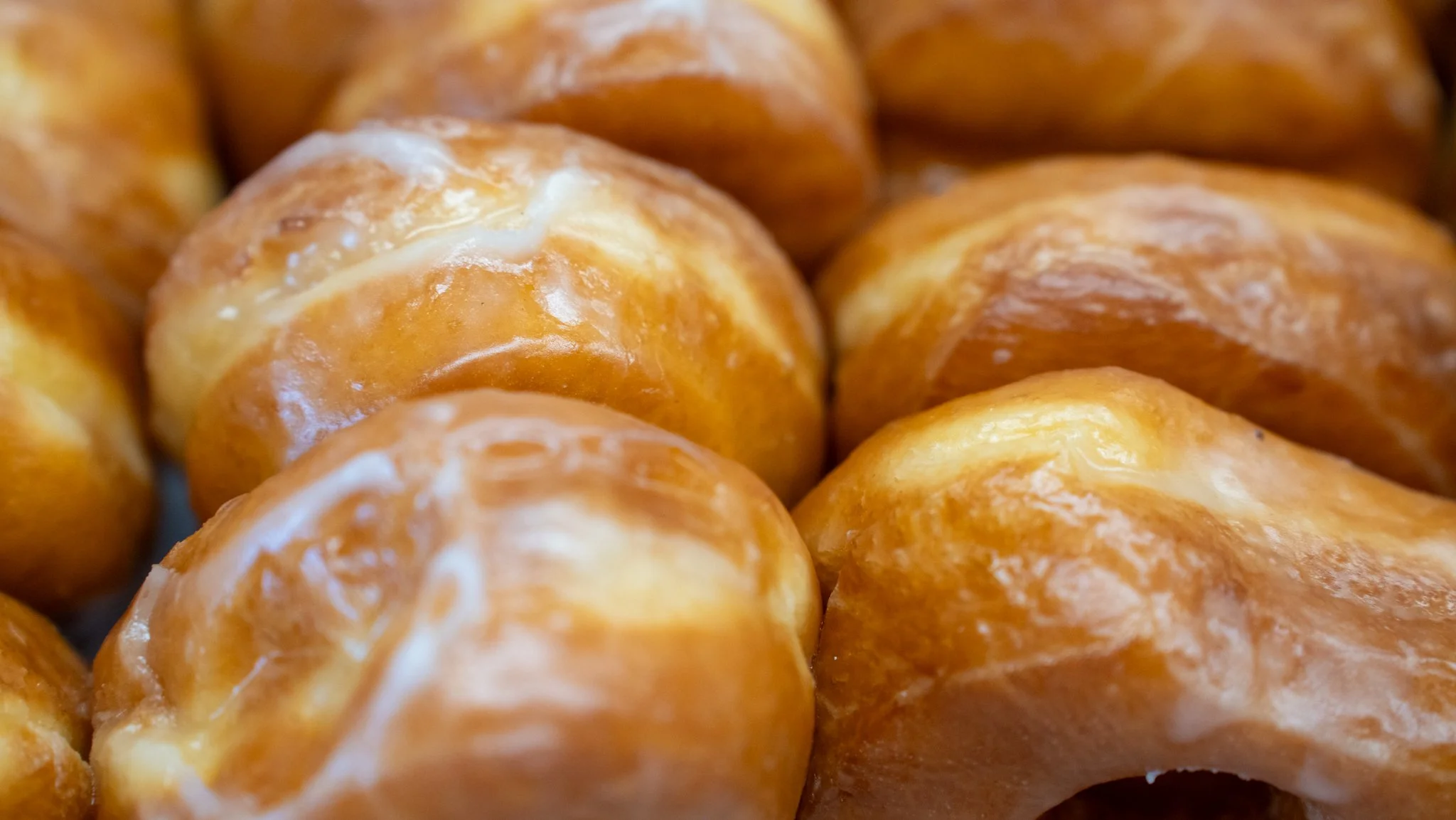 Close-up image of glazed, round bread rolls with a shiny, golden-brown crust.