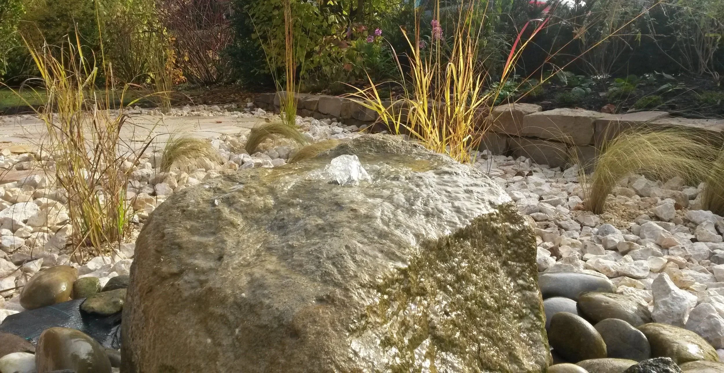 Ziergarten mit Naturstein, Wasserspiel, Quellstein, Ziergräsern und strukturierter Bepflanzung