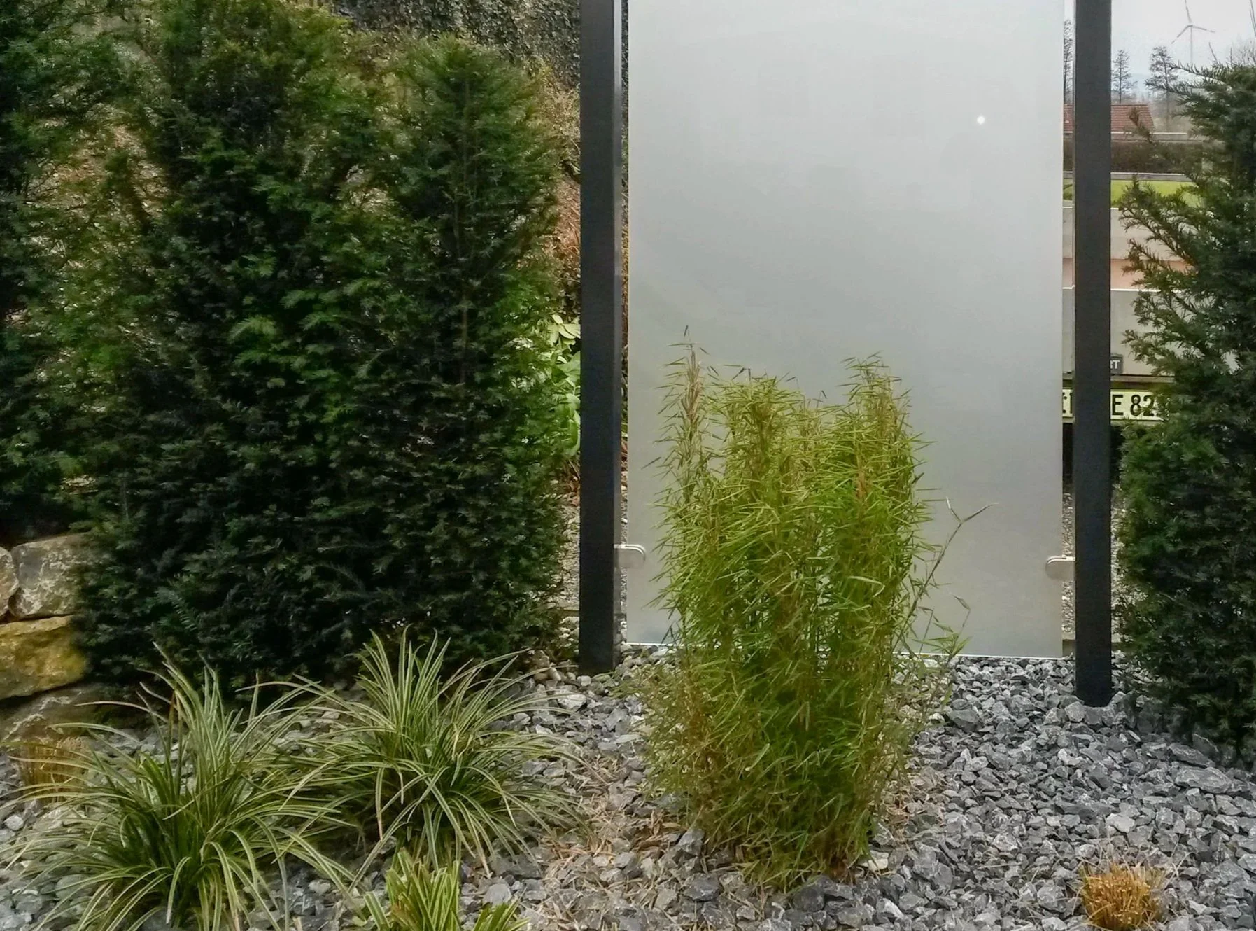 Modern gestalteter Garten mit Ziersträuchern, Kiesfläche und klaren Linien