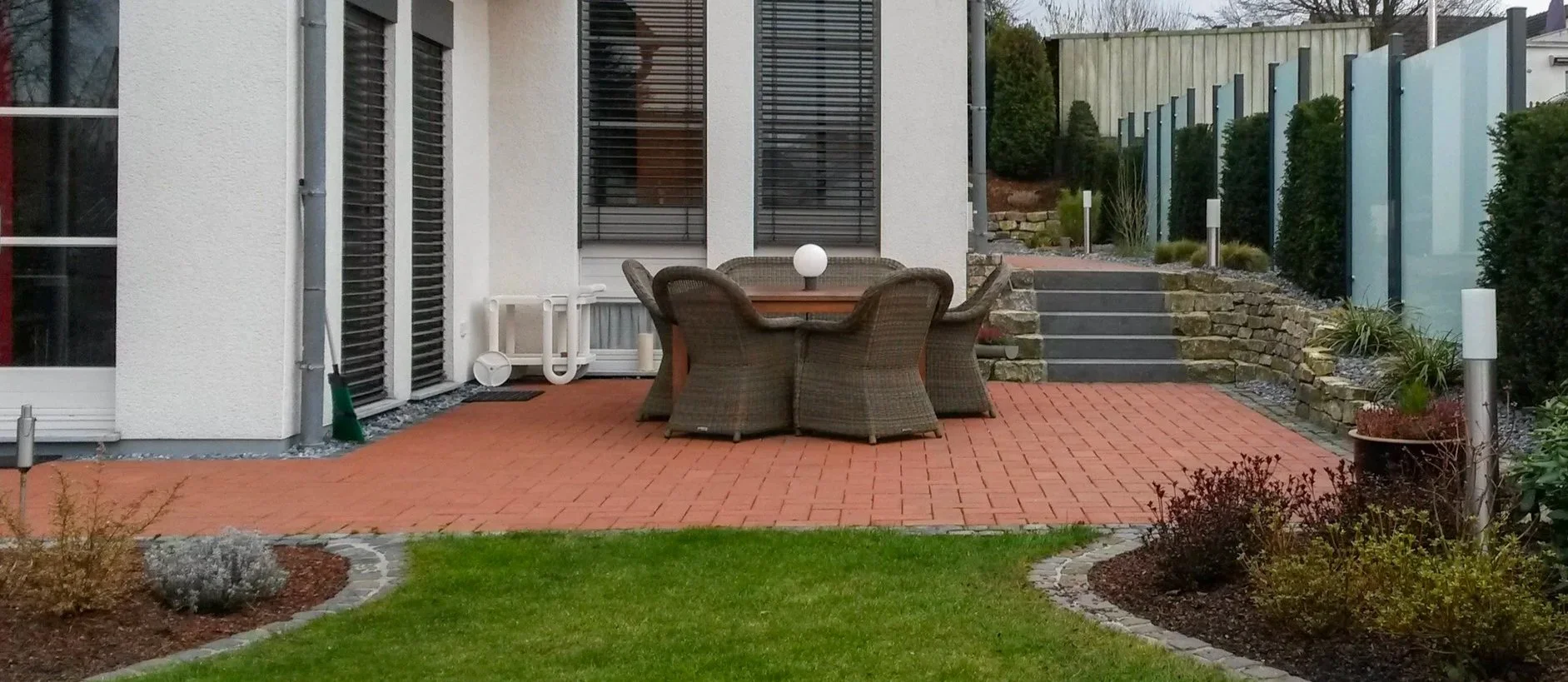 Modern gestalteter Garten mit Terrasse, Sitzbereich und Naturstein-Stufen