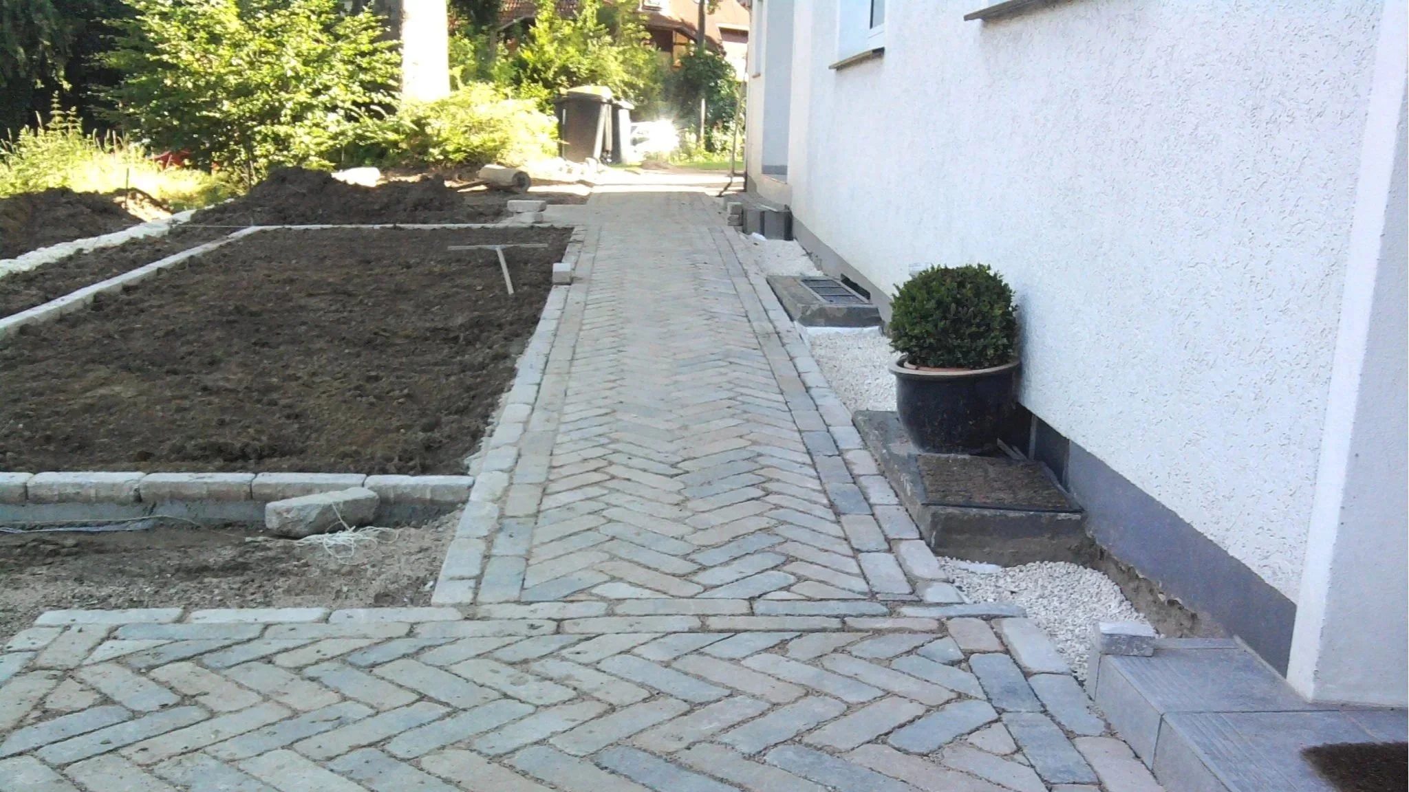 Pflasterarbeiten im Garten: Gehweg aus Naturstein im Hahnentritt-Muster