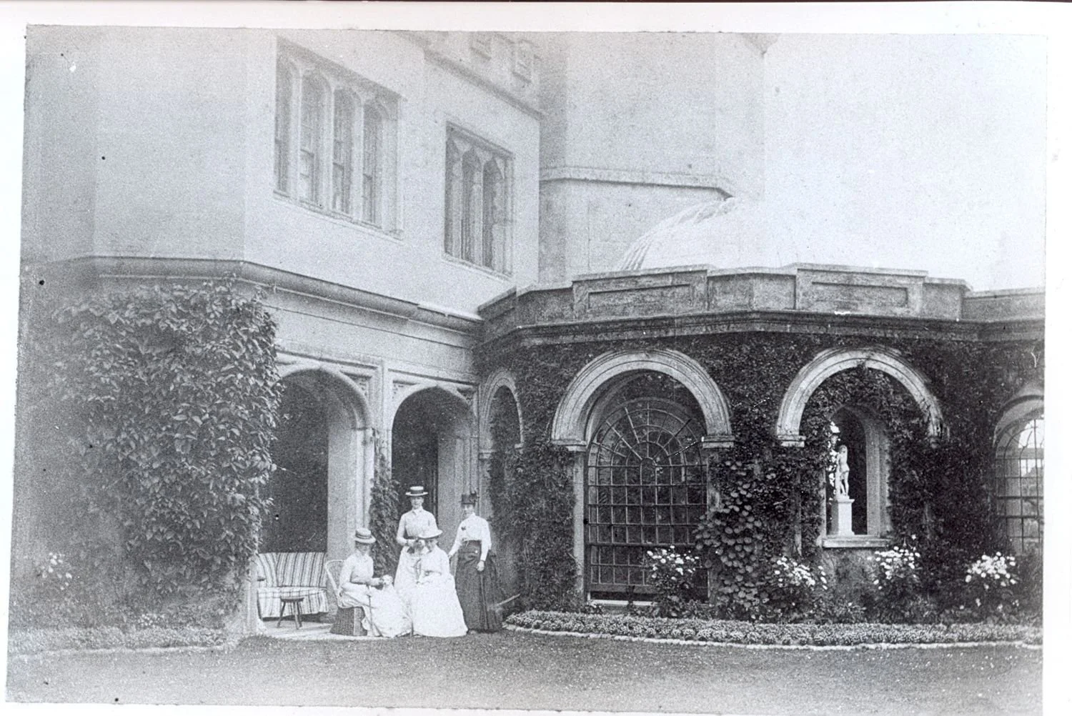 Vintage photograph showing conservatory added to Mount Edgcumbe House in 1840s.  Ladies in Edwardian dress appear in front.