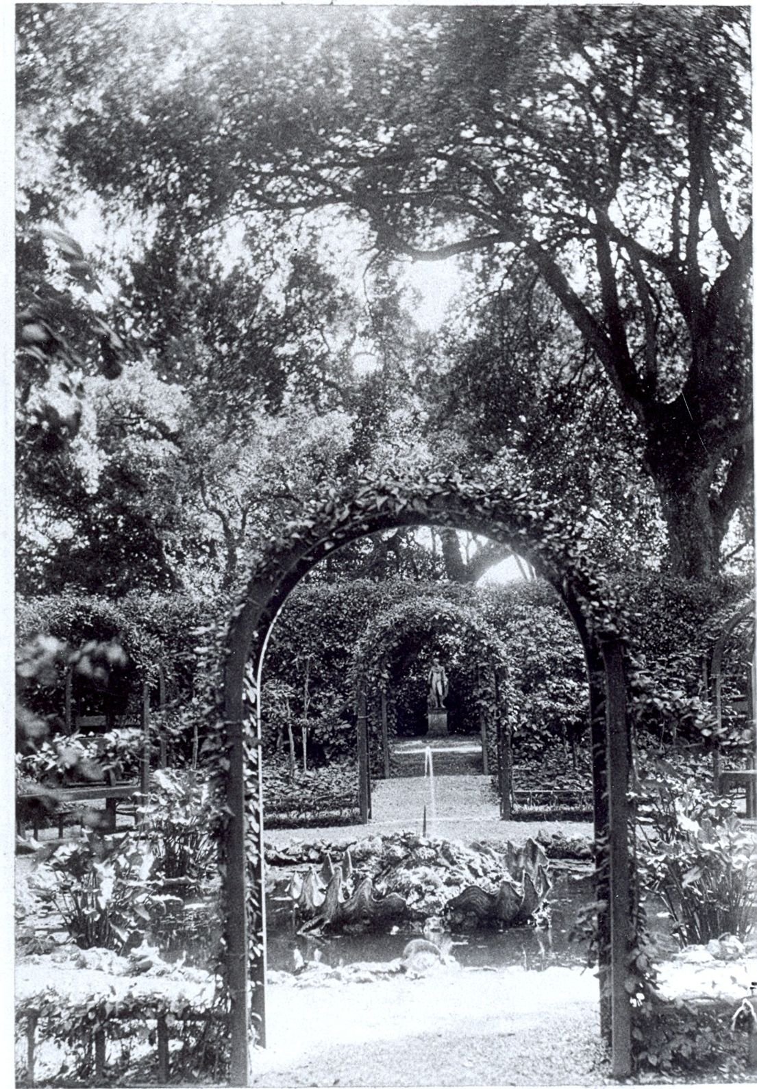 Vintage photo of the French Garden showing trellises, rococo pond, statuary and verdant planting.