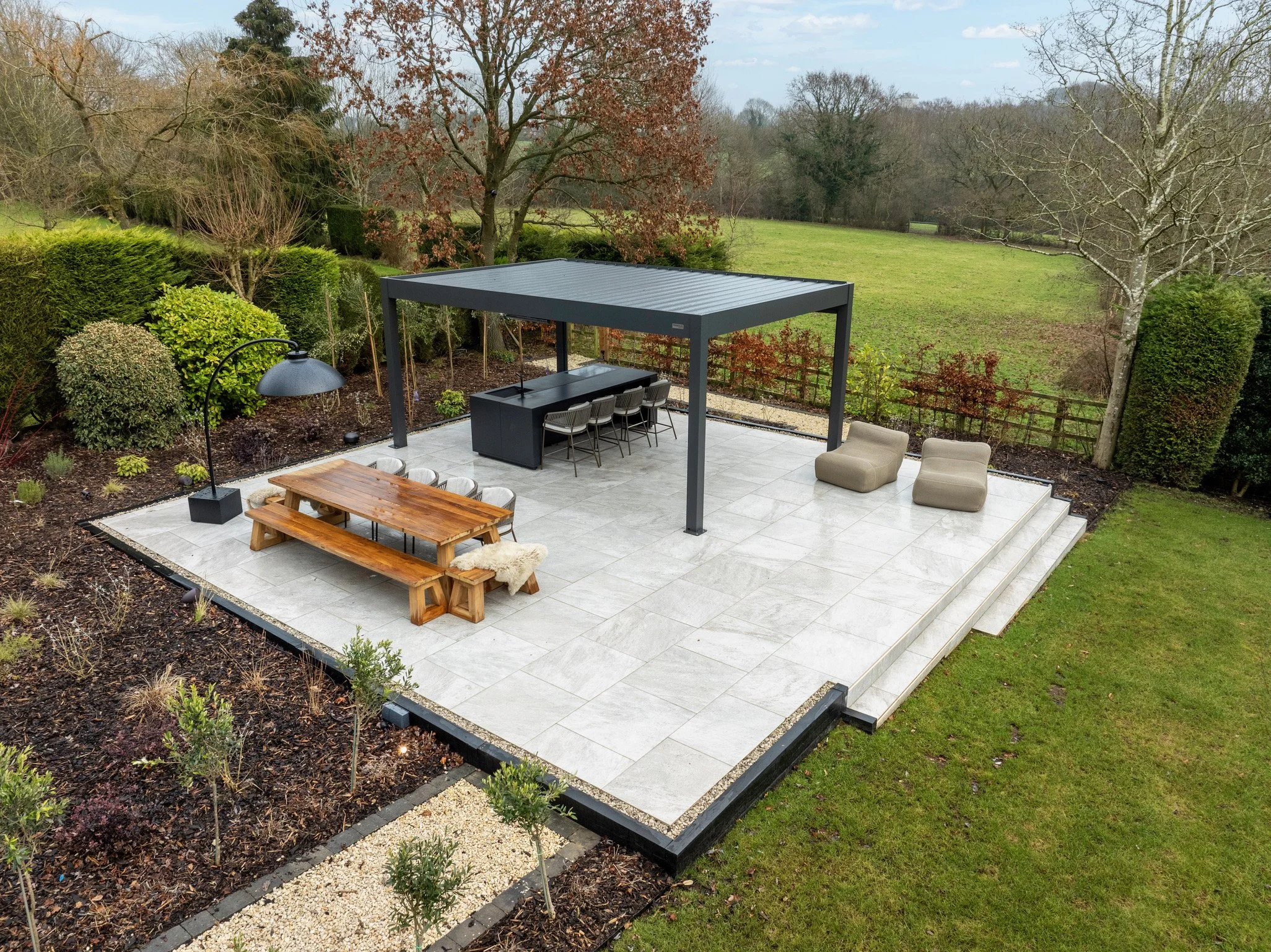 Outdoor dining terrace with integrated garden lighting and multi-zone outdoor audio