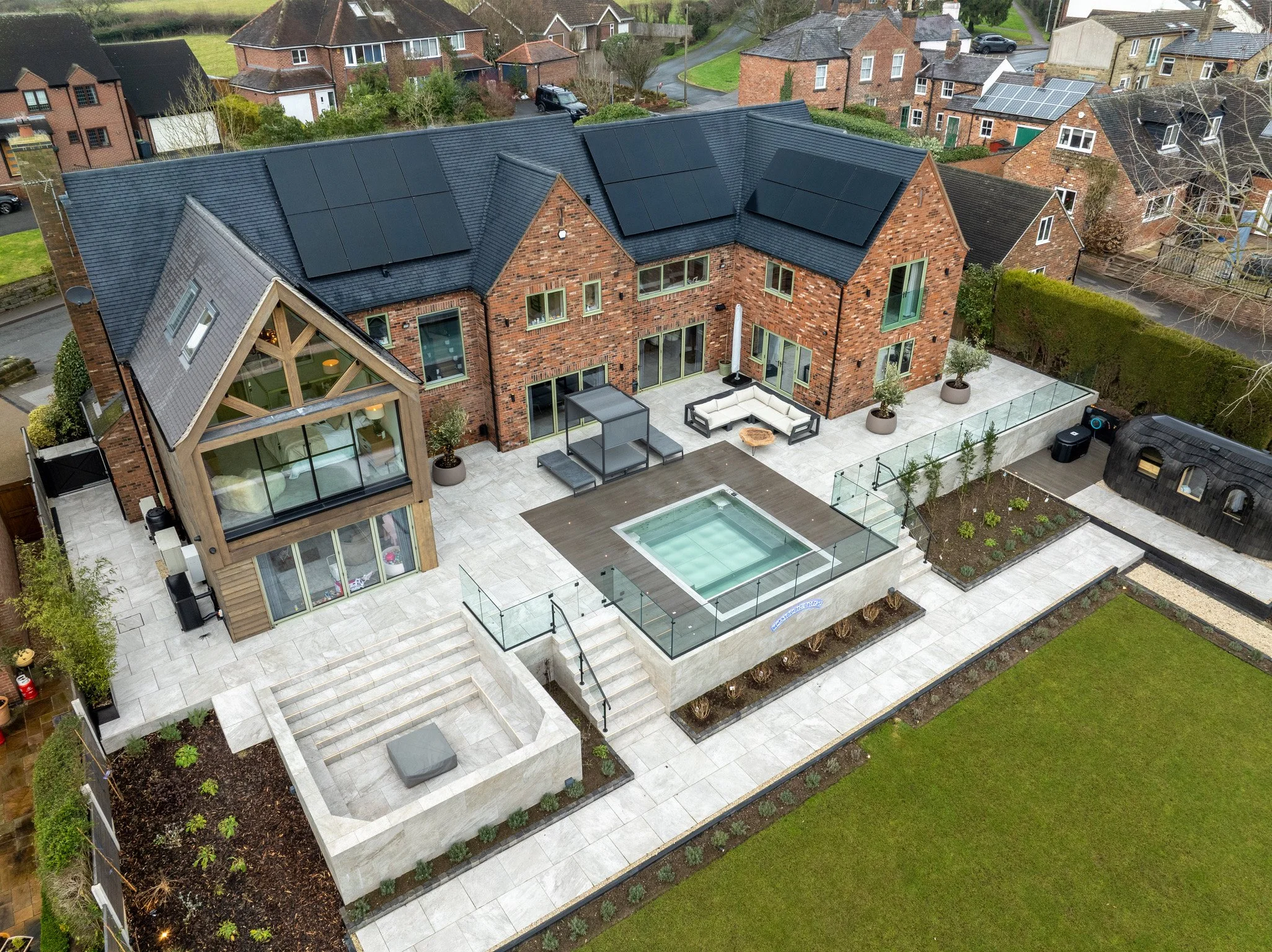 Drone view of landscaped garden with outdoor entertainment areas and integrated lighting design