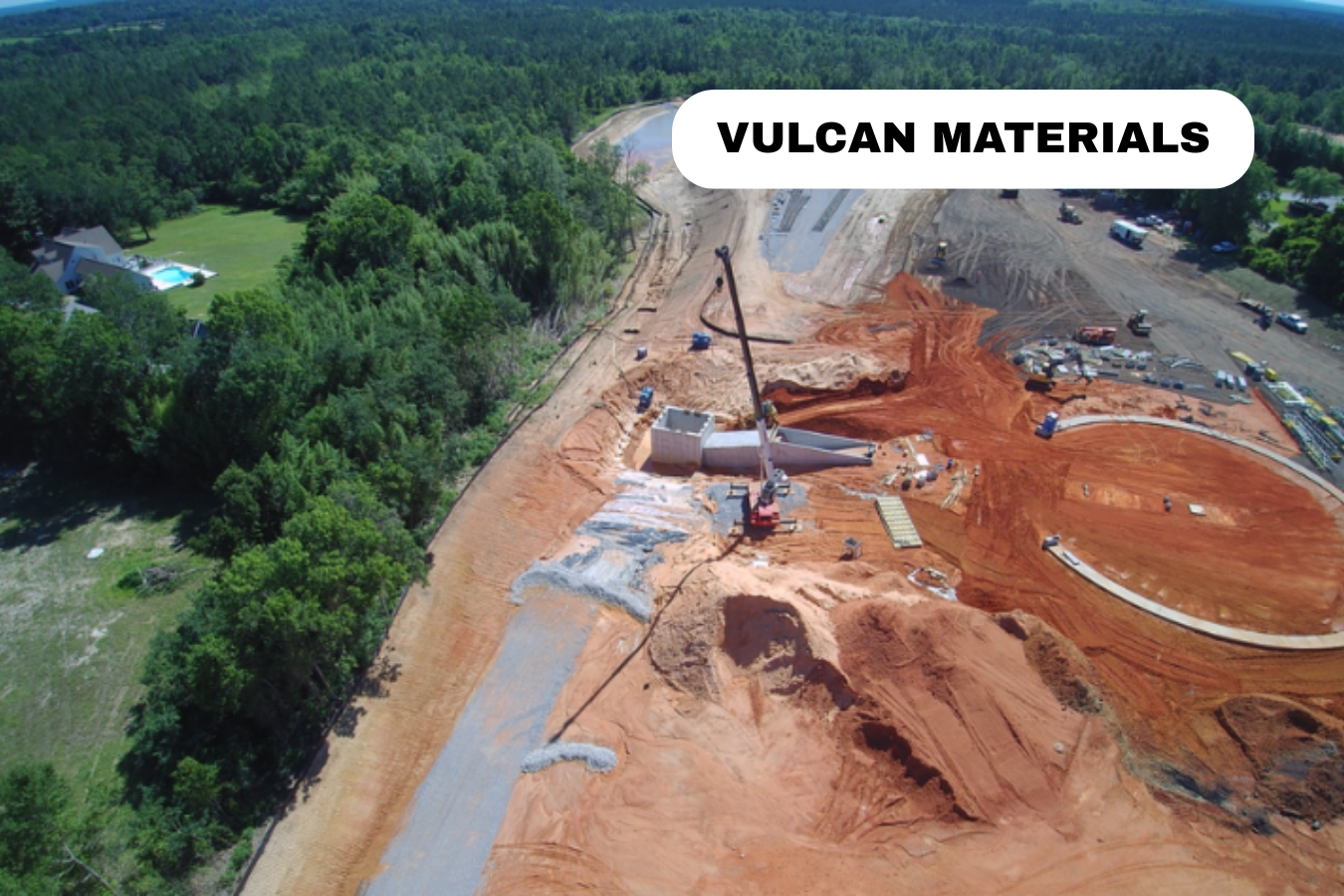 Construction site with excavation and dirt, surrounded by trees and greenery, with a label 'VULCAN MATERIALS'