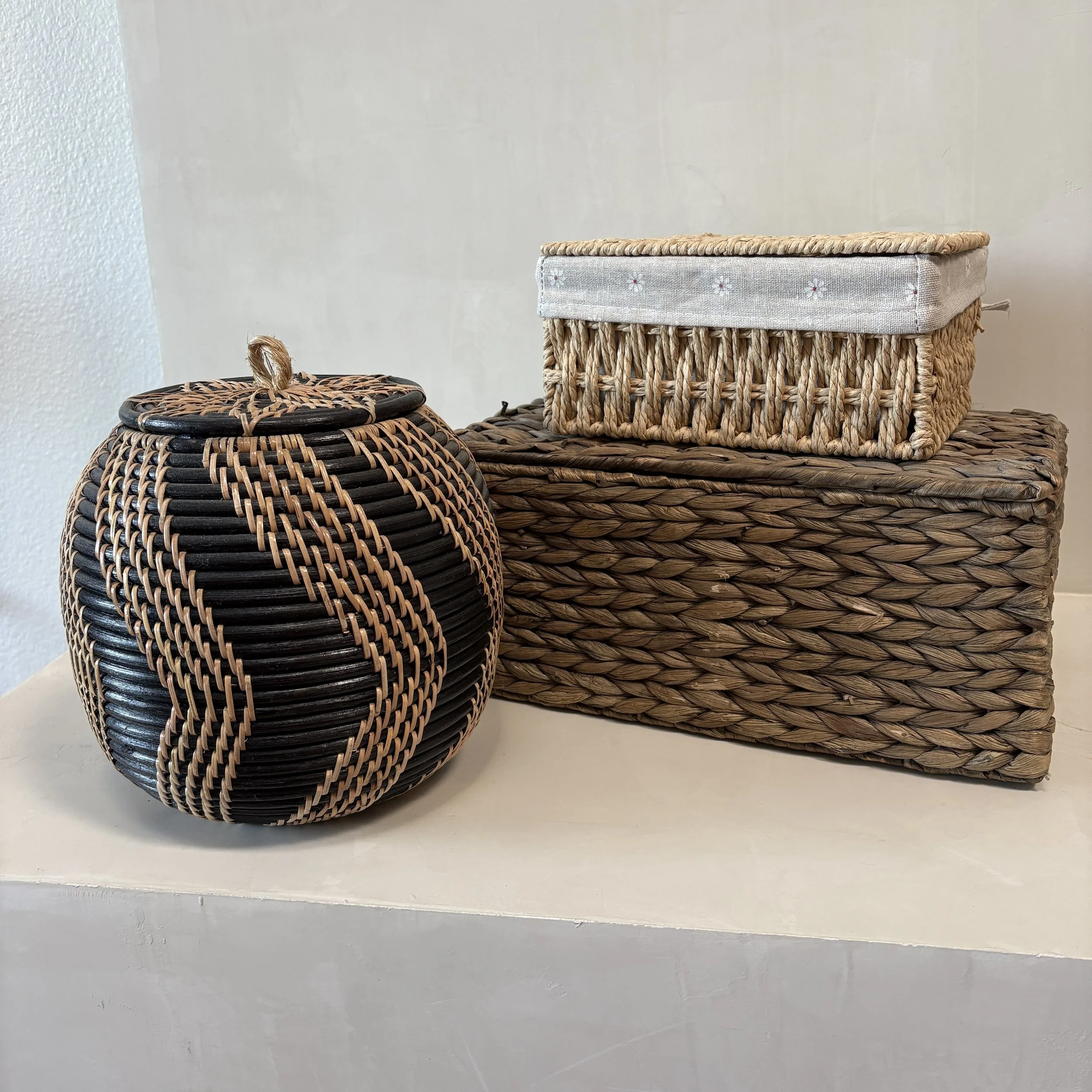Decorative woven baskets in neutral tones on a white surface.