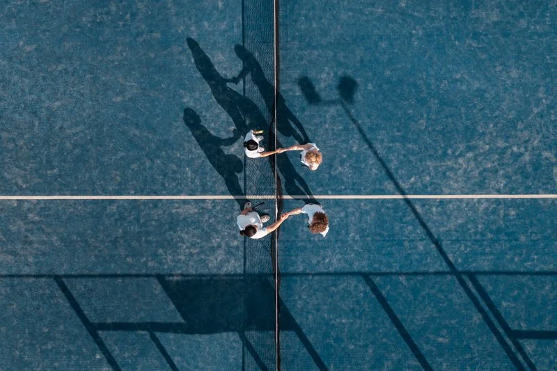 Plano cenital sobre parejas jugando al padel sobre un suelo azul