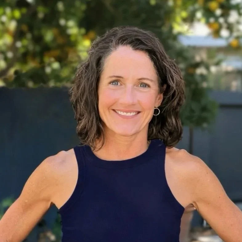 Peggy, Health & Wellness Coach, RN. A woman in a navy blue tank top appears in front of a blurred green and gray background.
